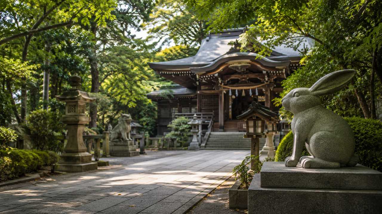浦和の歴史ある神社をイメージした実写風アイキャッチ画像。緑に包まれた静かな神社境内、石畳、木造の社殿、入口付近にうさぎの石像がある構図