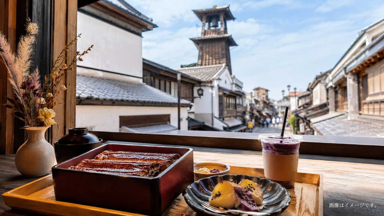 川越の蔵造りの町並みと時の鐘を背景に、手前に上品な和食ランチとうなぎ、さつまいもスイーツ、カフェドリンクを自然に配置した写真風ビジュアル