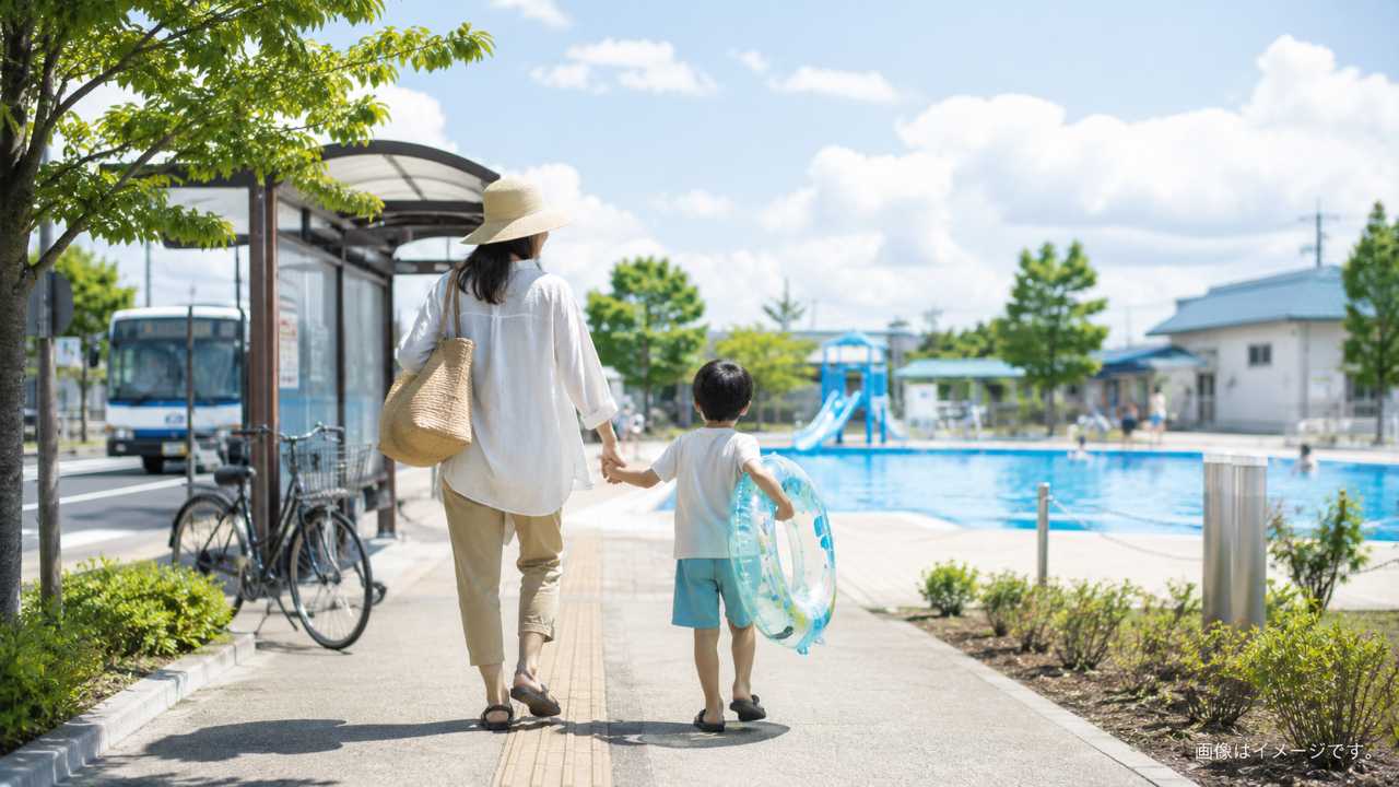 夏の屋外市民プールへ向かう親子と、近くのバス停や自転車