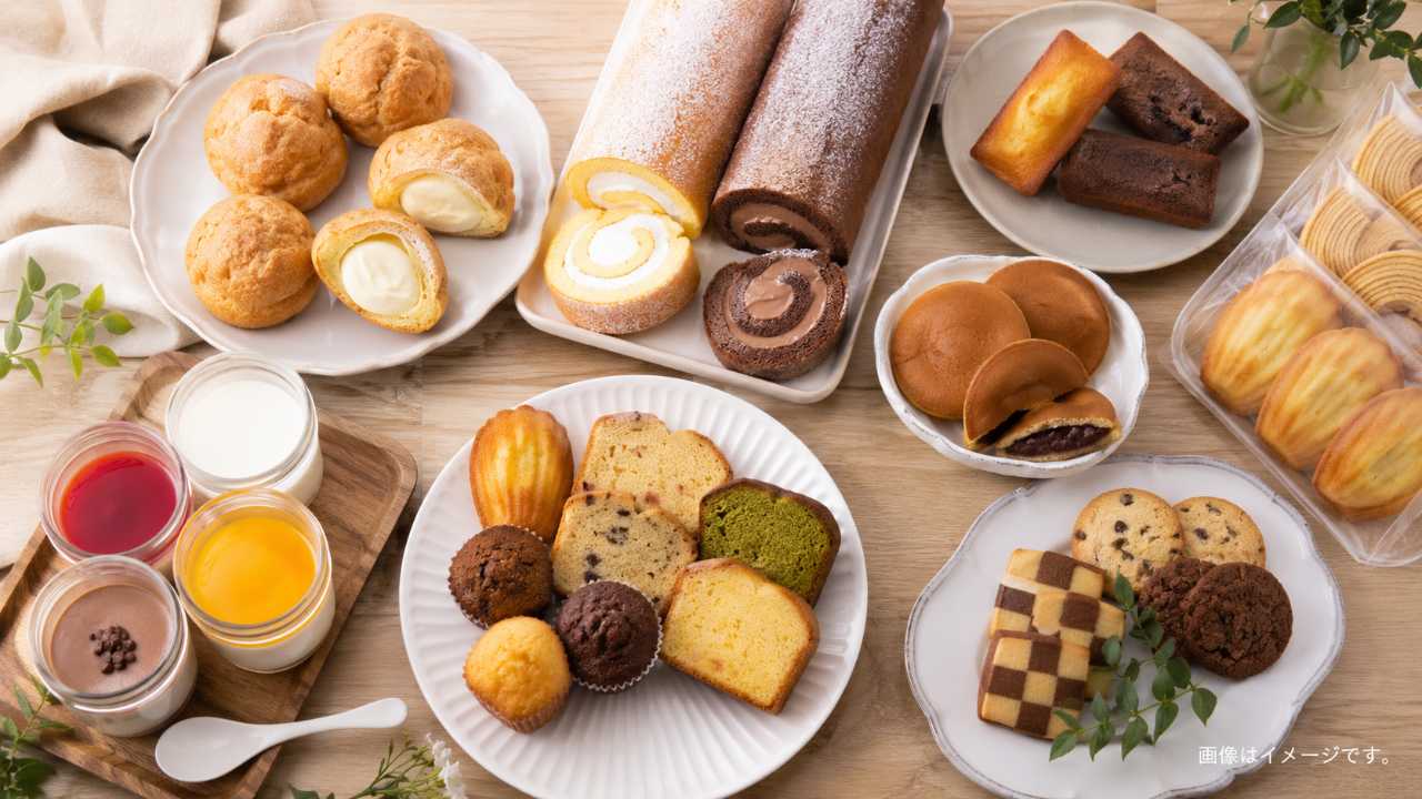訳ありスイーツ、ロールケーキ、シュークリーム、焼き菓子をテーブルに並べた実写風