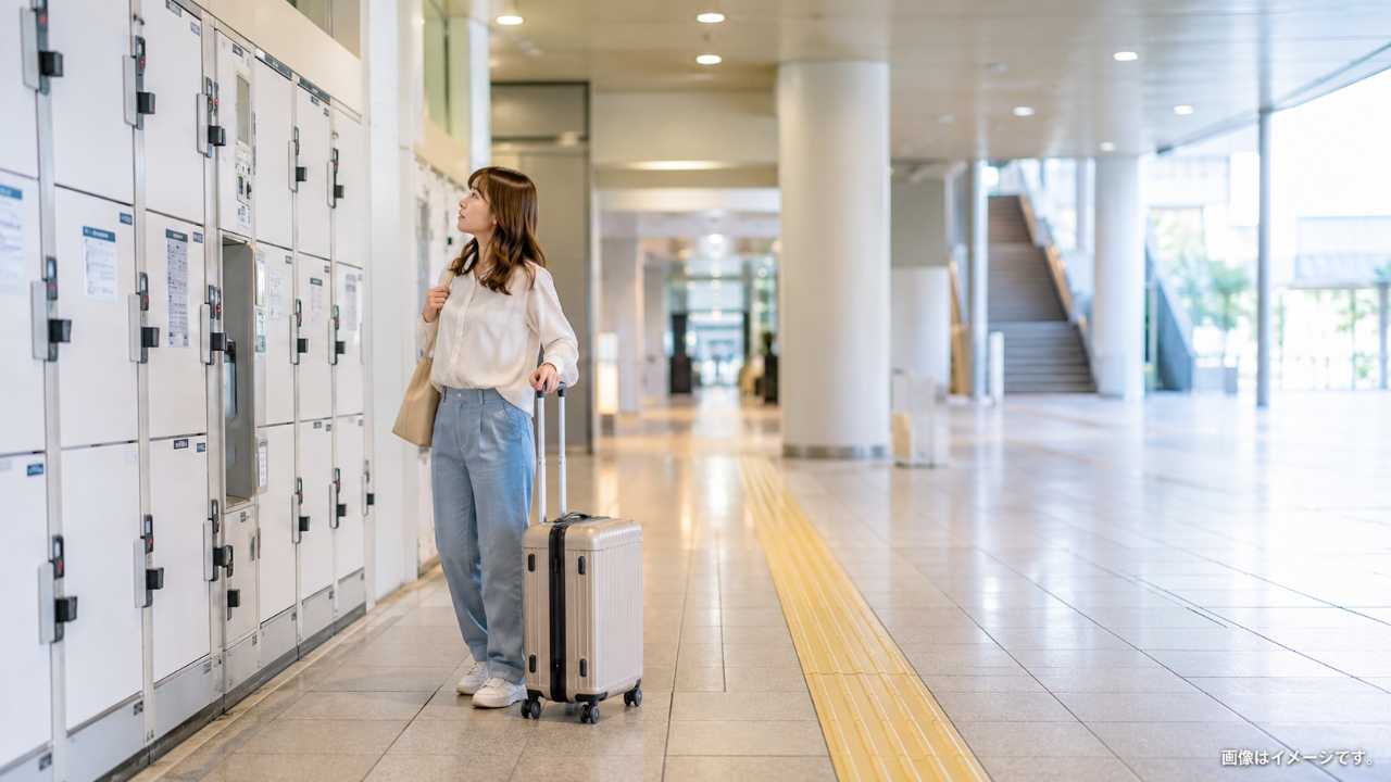 南浦和駅周辺で旅行者がスーツケースを持ち、駅構内のコインロッカーを探している自然な写真