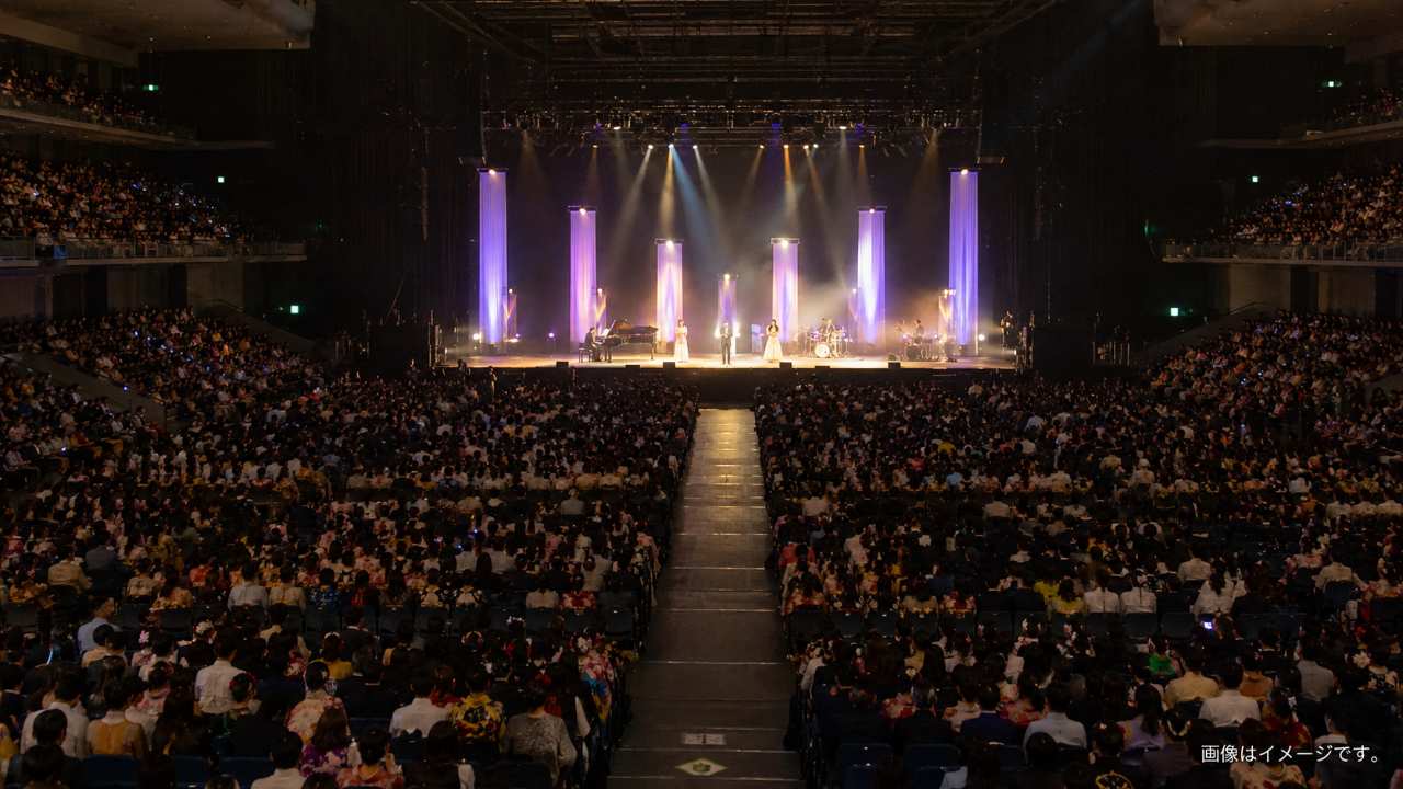 大規模アリーナのステージでミニライブが行われている雰囲気の写真風画像