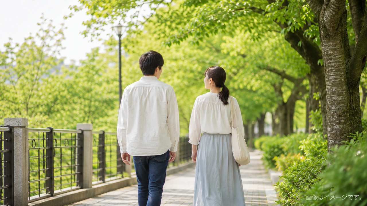 埼玉の無料デートをテーマにしたブログ用アイキャッチ画像。緑豊かな公園の遊歩道を若いカップルが並んで歩く後ろ姿