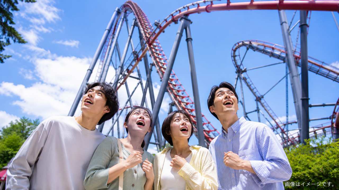 怖いけれど楽しそうにジェットコースターを見上げる友人グループ