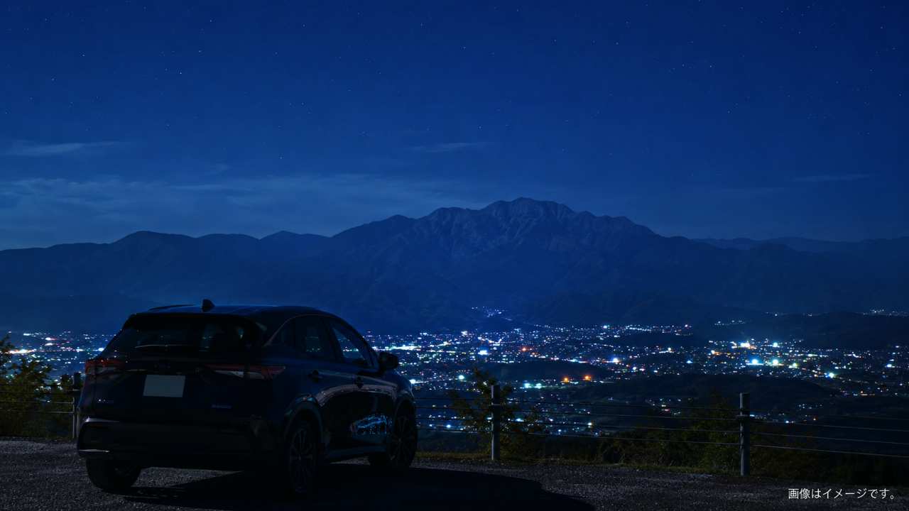 夜の埼玉をドライブするイメージ。手前に停車した車のシルエット、奥に秩父の山並みと街の夜景