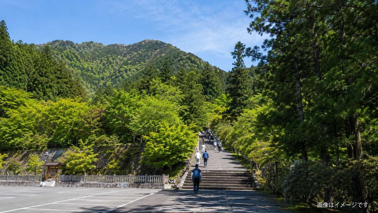 山間部にある市営三峰駐車場から三峯神社の参道へ向かう階段と上り坂を写した実写風の観光写真