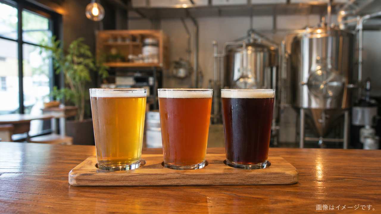 クラフトビールの小さなグラスを3種類、木製カウンターに並べた実写風の飲み比べセット