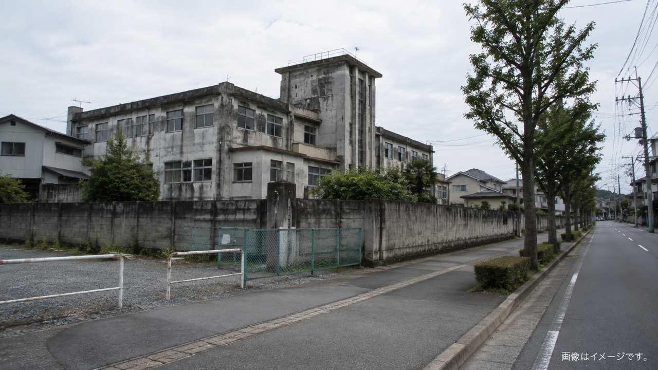 旧病院の外観と周囲の住宅地を公道側から見渡す様子